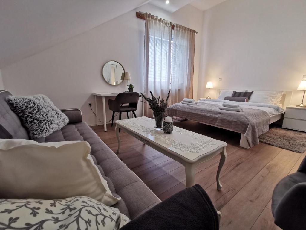 Sala de estar con sofá, cama y mesa en Elysian Apartments, en Grabovac