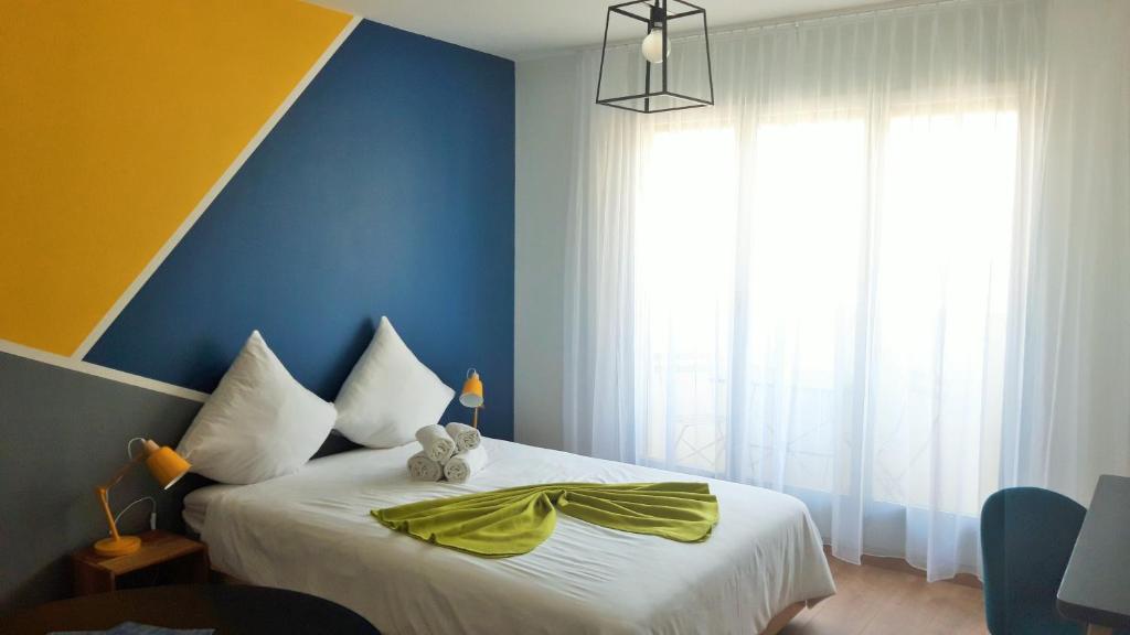 Studio vue imprenable في سييرا: غرفة نوم بسرير بجدار اصفر وزرق