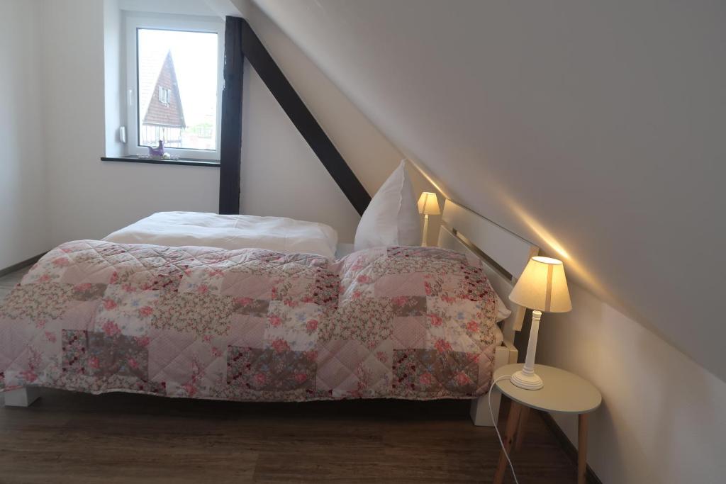 um quarto com uma cama com uma colcha e uma janela em Landpension zur Hainbuche em Romrod