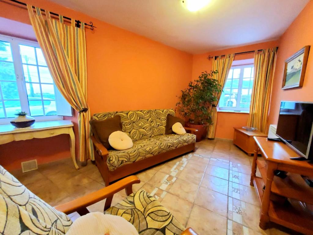 a living room with a couch and a tv at Apartamentos Turísticos Rosa in Ribadeo