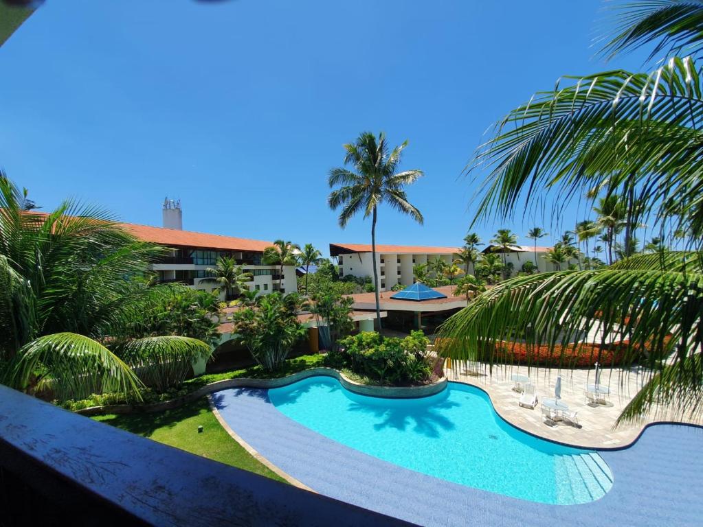 - une piscine dans un complexe avec des palmiers dans l'établissement Flat Marulhos Porto de Galinhas - 305D, à Porto de Galinhas