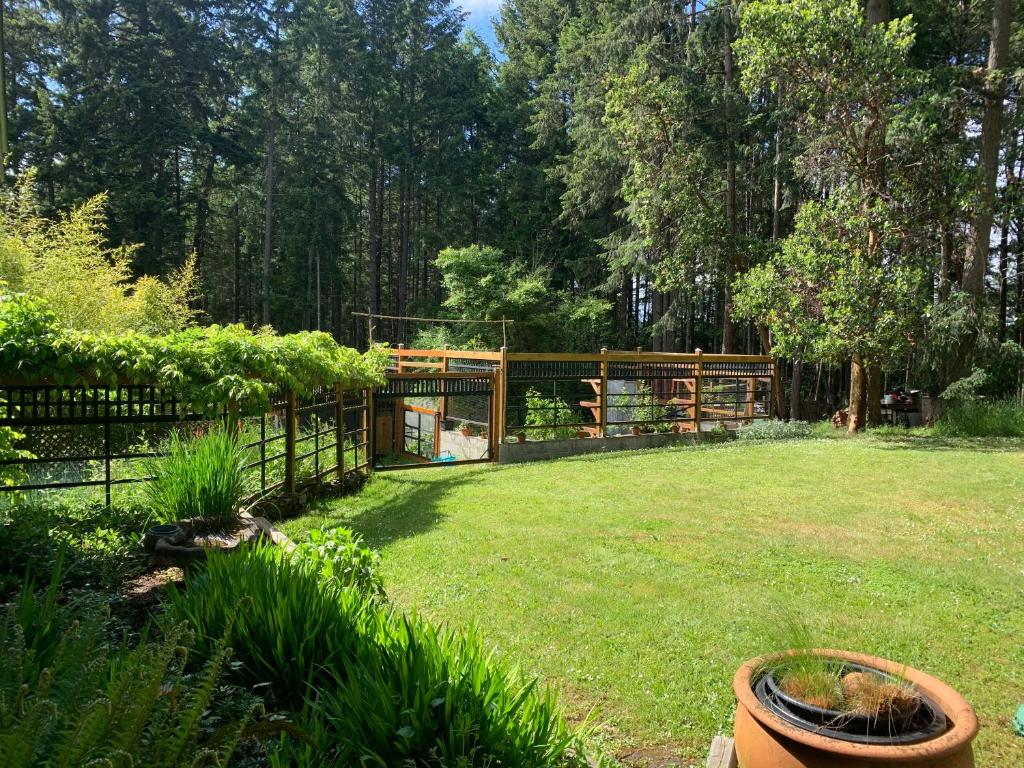 a yard with a fence and a garden at Salt Spring Carriage House B&B in Ganges