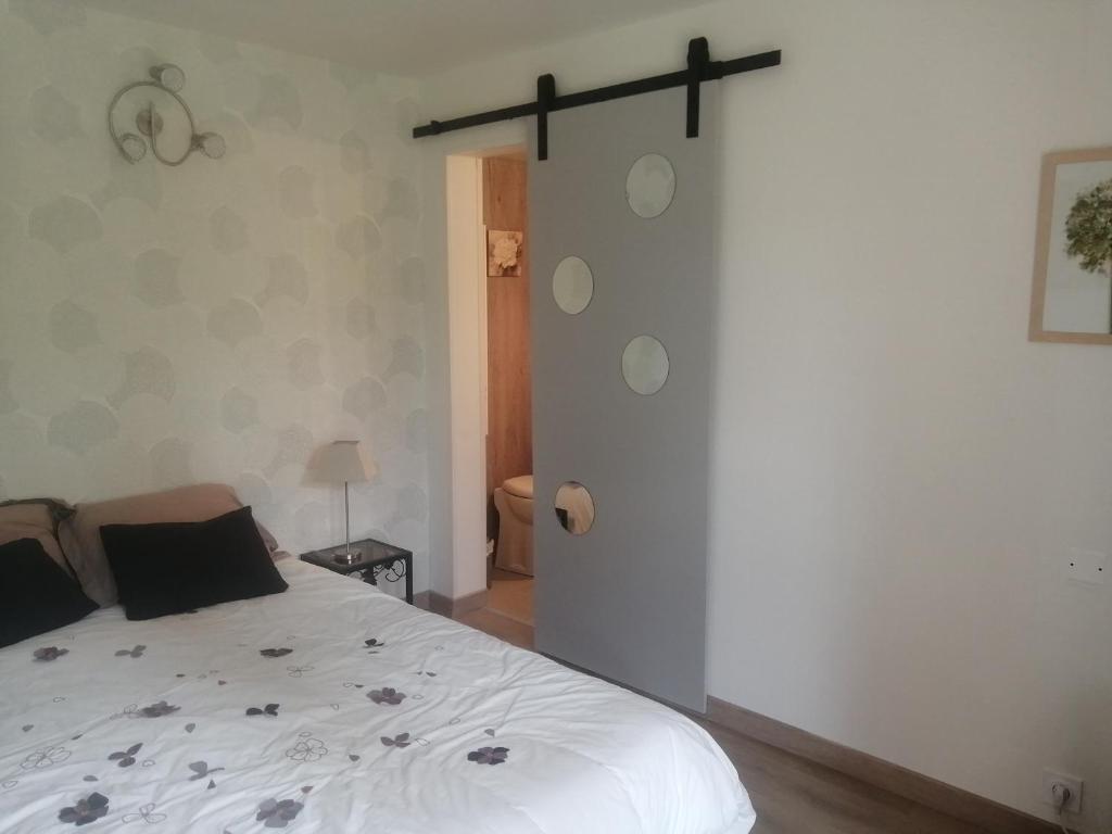 1 dormitorio con cama blanca y pared blanca en Le petit nid, en Égletons