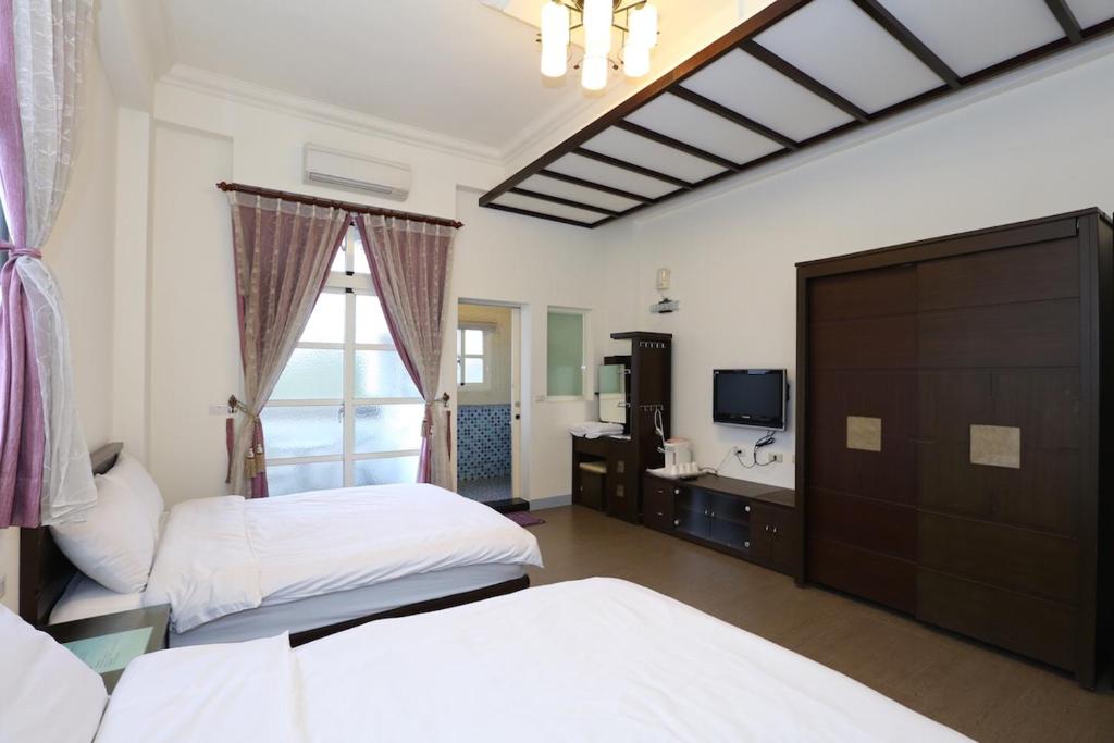冬山鄉的住宿－松舍民宿，一间卧室配有两张床、一个水槽和一台电视。