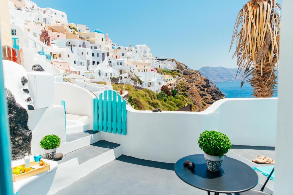 a view of the amalfi coast from a balcony with a table at Blessed Blue Boutique Cave Suite in Oia