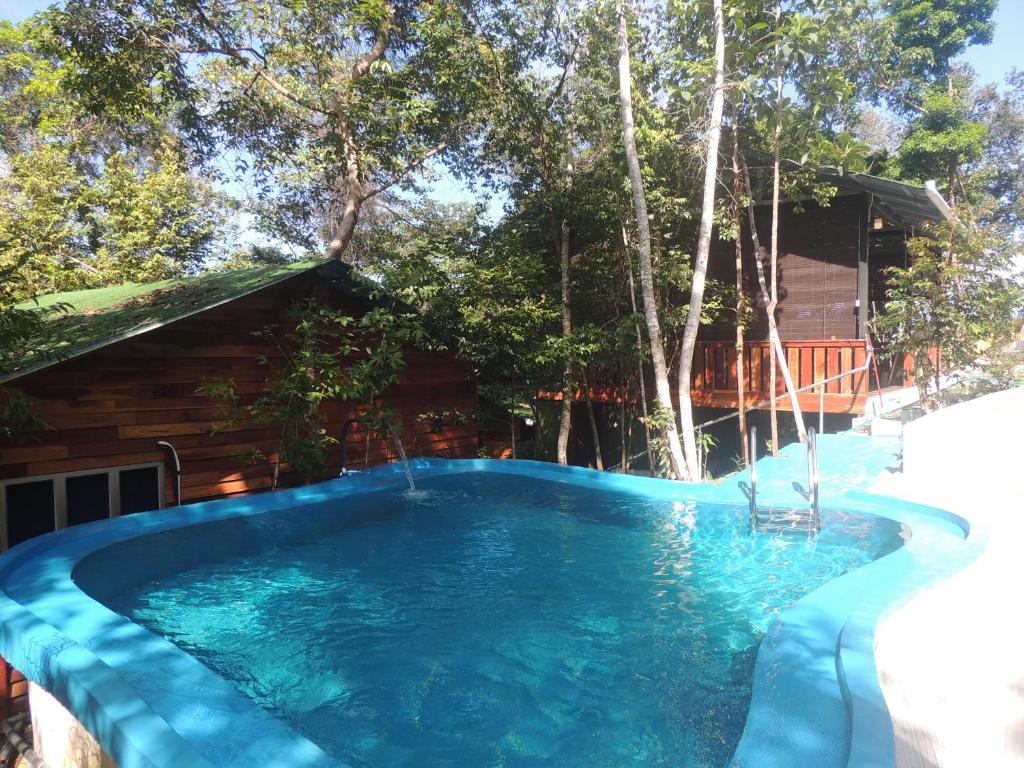 a swimming pool in front of a house with trees at Utan Teluk Nipah in Pangkor