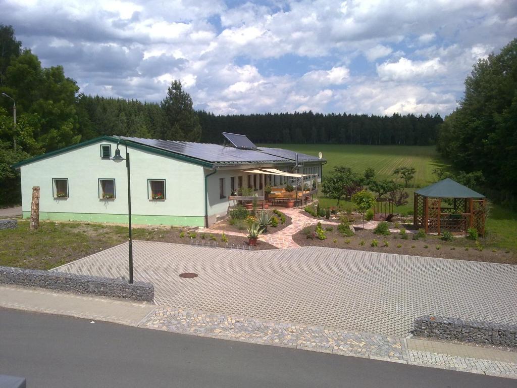 una casa blanca con un cenador frente a ella en Landpension Wandersruh, en Langenberg