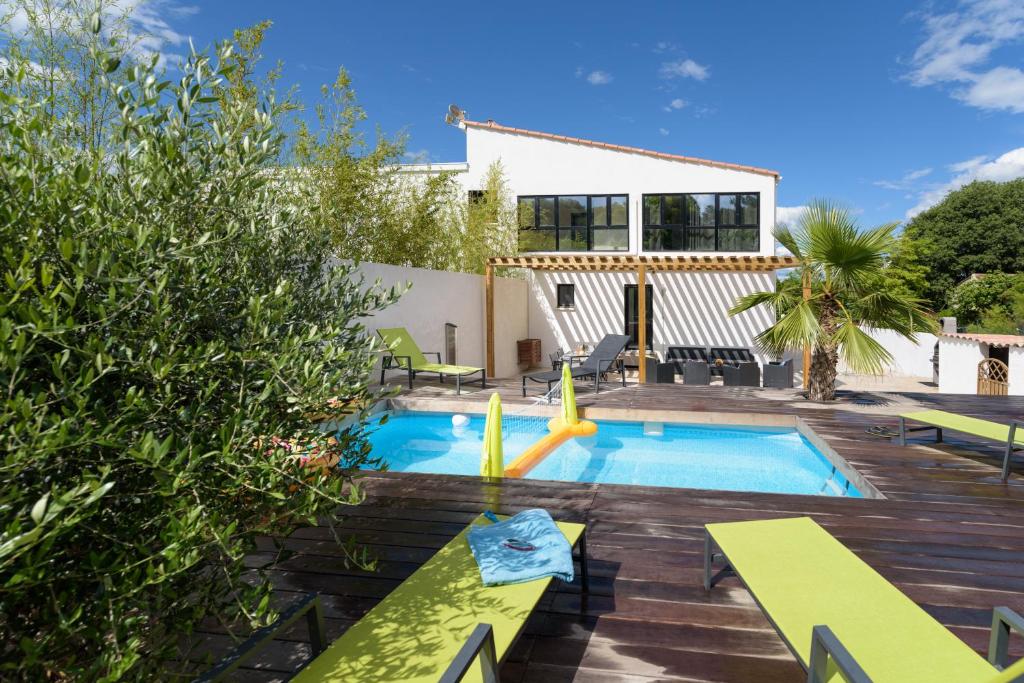 una piscina con tobogán y una casa en Villa Holidays - Piscine chauffée et privée - clim - wifi - parking privée - Netflix, en Grabels