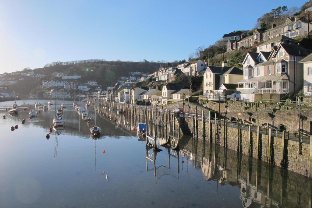 a river with boats in the water and houses at Shellseekers Guest House in Looe