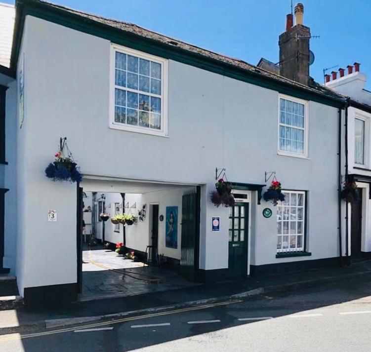 a white building with flowers on the side of it at Little Mermaid Cottage in Dawlish