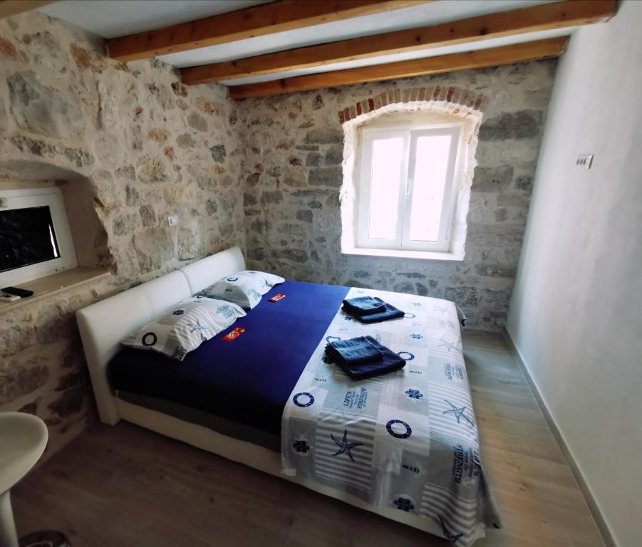 ein Schlafzimmer mit einem Bett in einem Zimmer mit einem Fenster in der Unterkunft Nanna's little paradise in Hvar