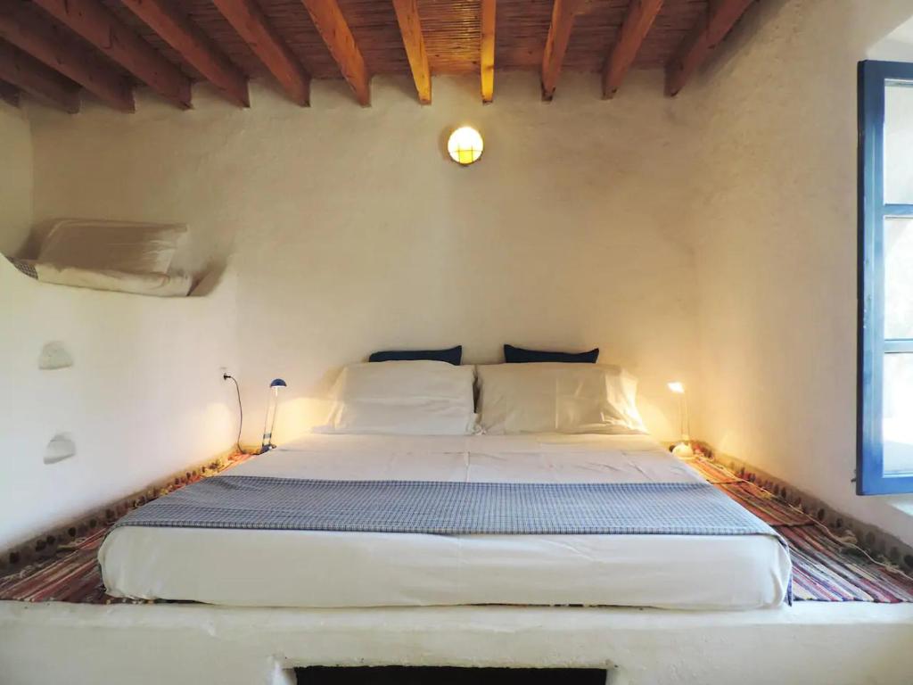 a bedroom with a large bed in a room at Lovely independent room in Ecovilla on the beach in Apolakkiá