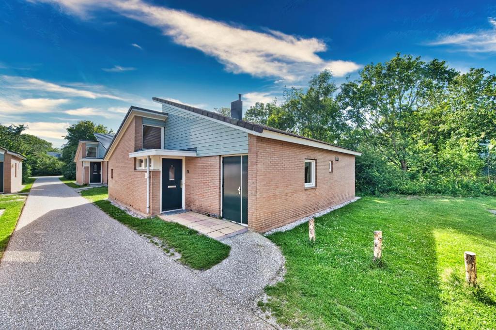 a brick house with a driveway at Kijkduinhuis in Monster