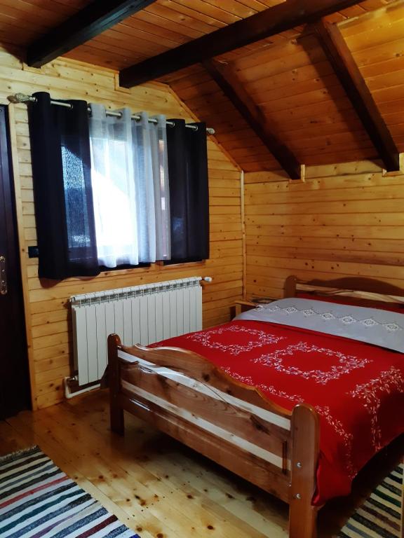 ein Schlafzimmer mit einem Bett in einem Holzzimmer in der Unterkunft Cabana La Mariuca in Borsa