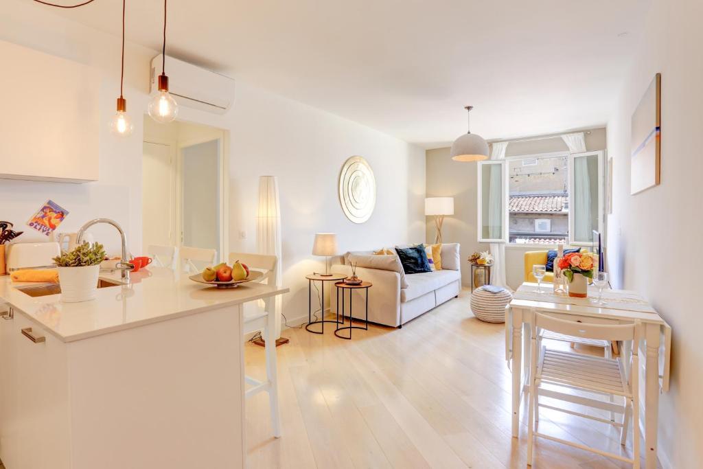 un salon avec une cuisine et un salon avec un canapé dans l'établissement Lou C -CHARMANT APT, CLIM, WIFI, REFAIT A NEUF, 6PERS, à Nice