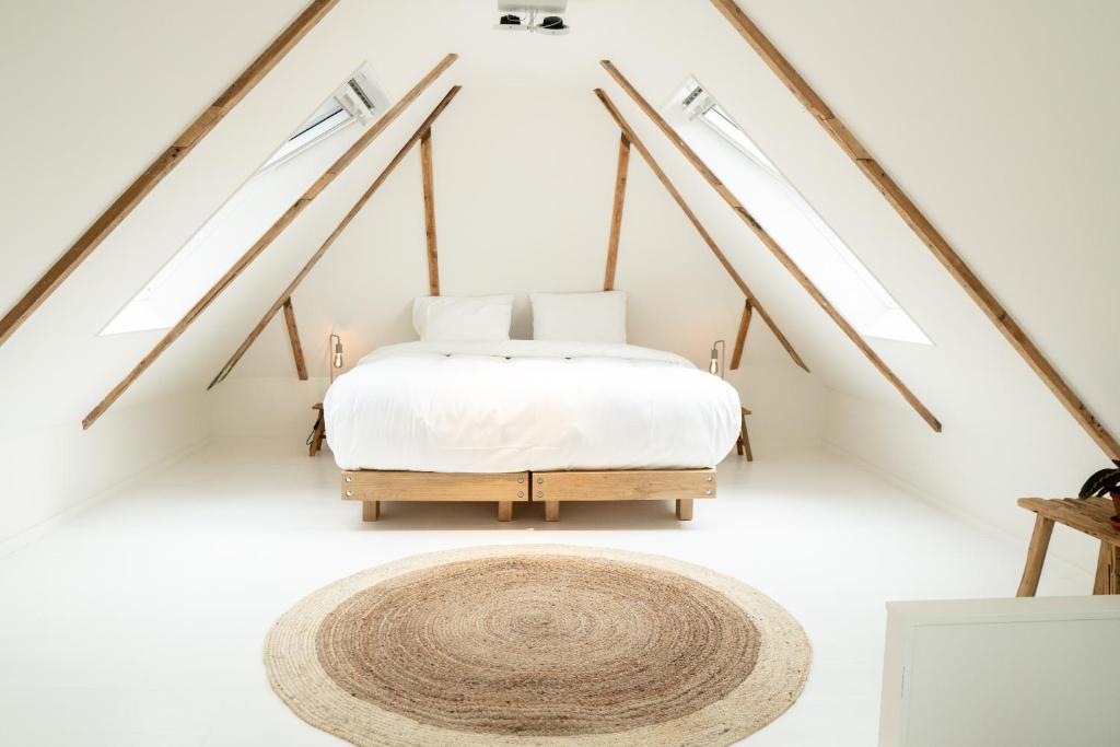 a bedroom with a bed with four windows at Nobel Houses & Lofts in Ballum