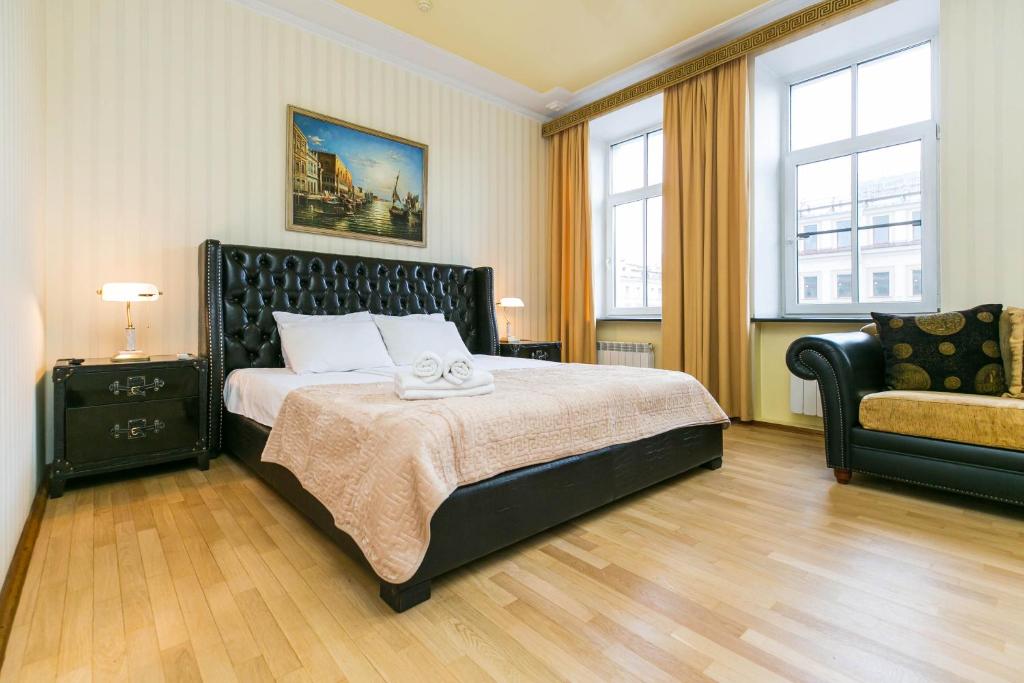 1 dormitorio con 1 cama, 1 sofá y 2 ventanas en Hotel Nevskiy 98, en San Petersburgo