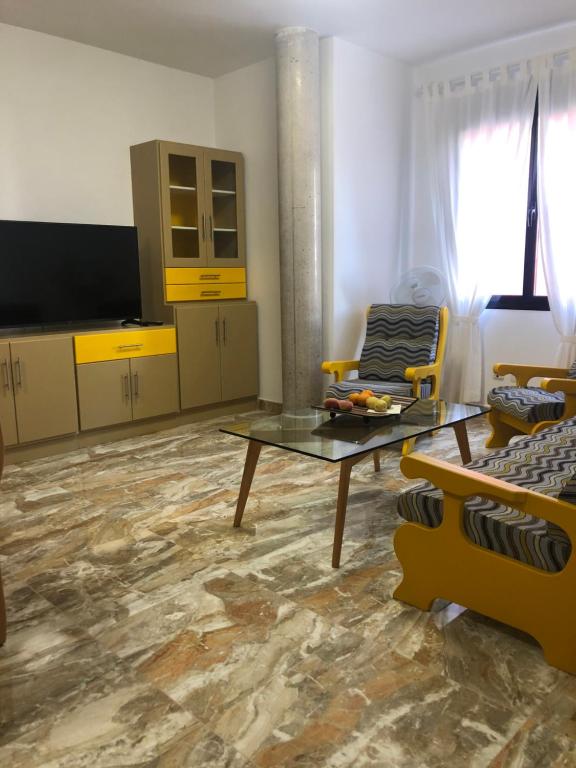 een woonkamer met een tafel en gele kasten bij Lujan 3C entre cielo y mar in Puntallana