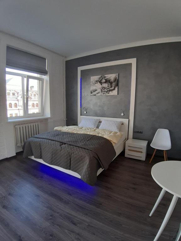 a bedroom with a large bed and a table at Яркая история in Kyiv