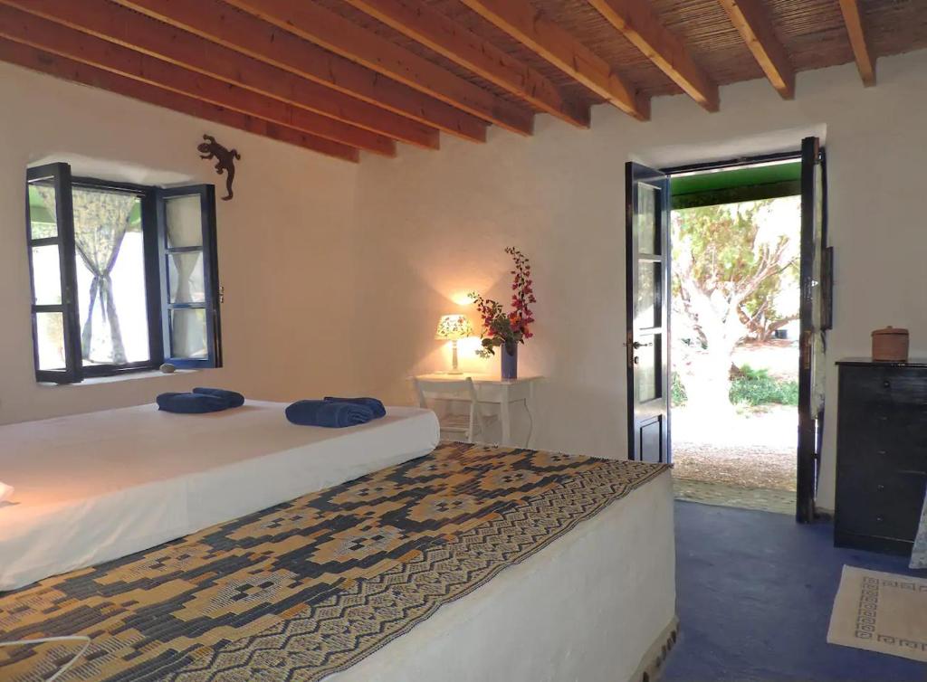 1 dormitorio con 1 cama y puerta a un patio en Exclusive apartment in Ecovilla on the beach, en Apolakkiá