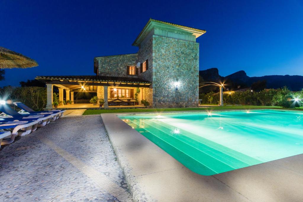 a villa with a swimming pool at night at Villa La Rafal By homevillas360 in Pollença