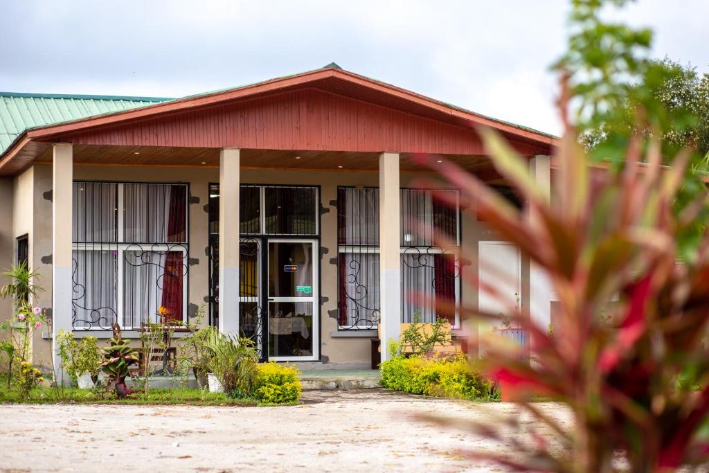 a small house with a red roof and windows at Andasibe Lemurs Lodge in Andasibe