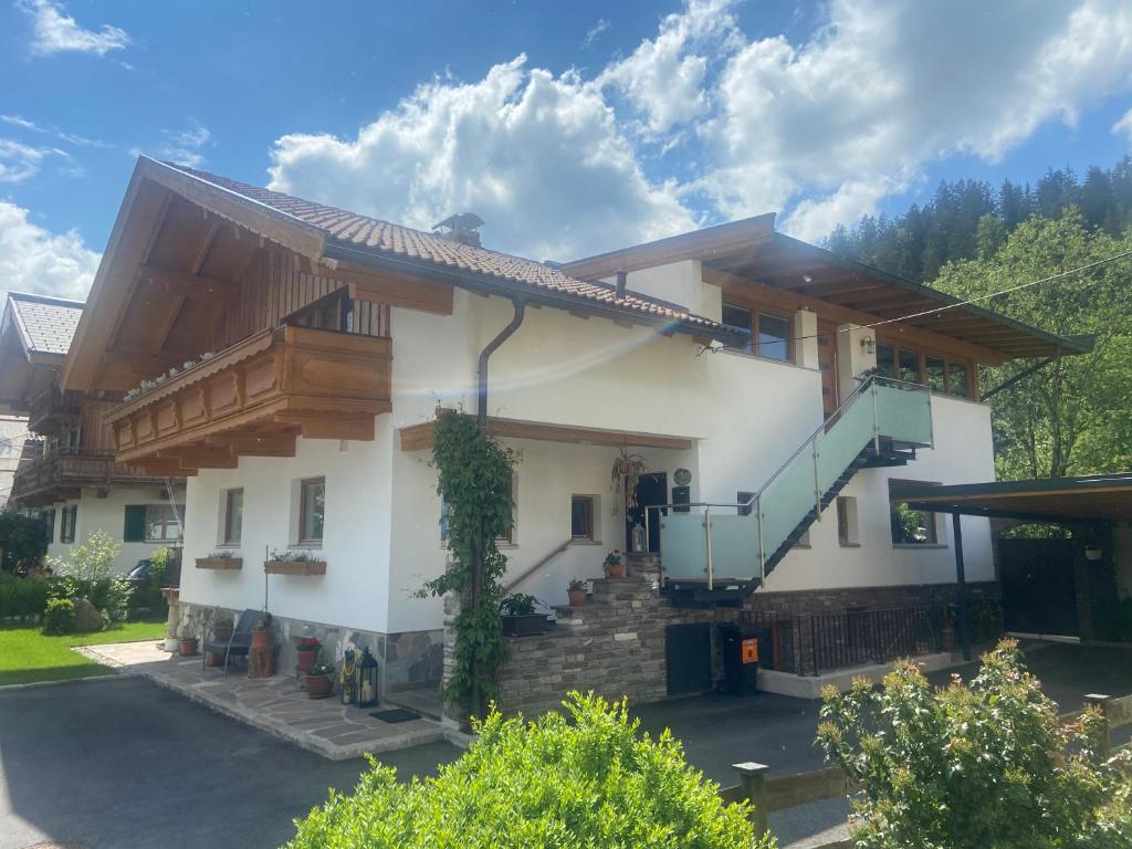 a large white house with a balcony and stairs at Apart Linde in Hopfgarten im Brixental