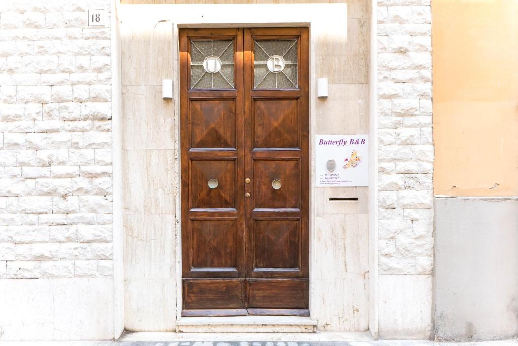 una puerta de madera en el lateral de un edificio en butterfly b&b en Livorno