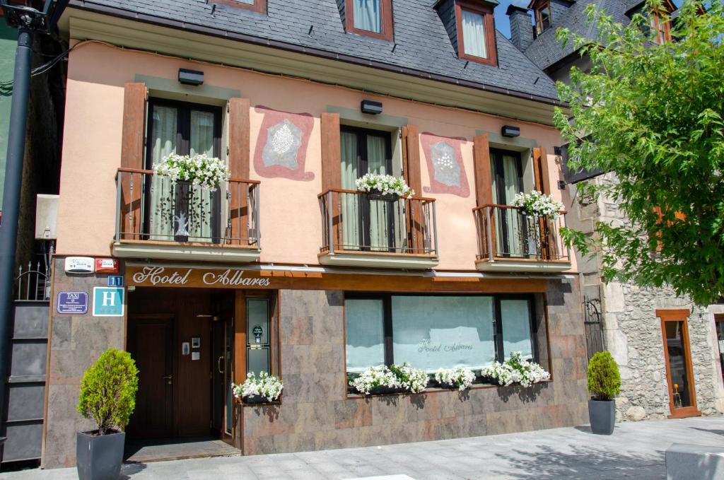 a building with potted plants on the windows of it at Albares in Vielha