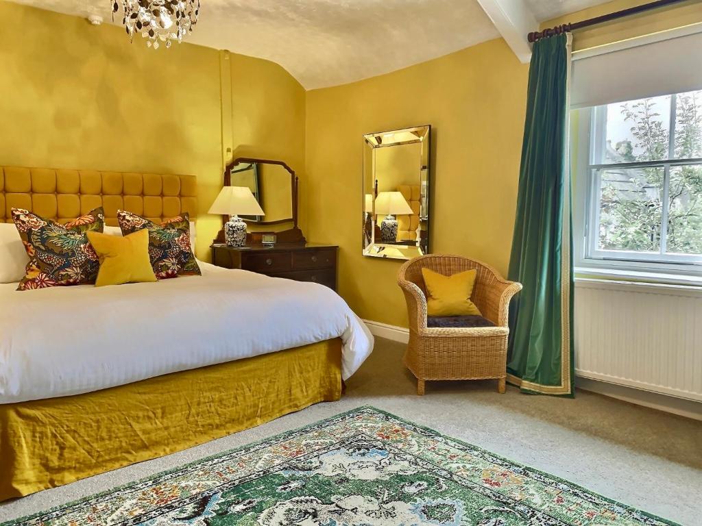 a bedroom with a bed and a mirror and a chair at Grove House in Leyburn