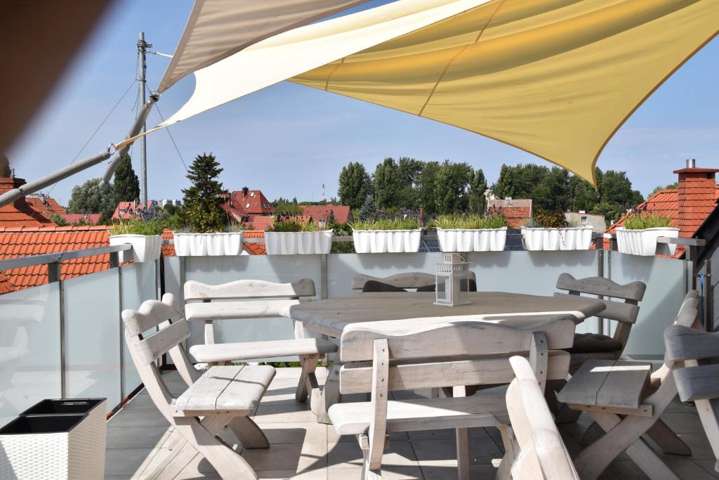 a table and chairs on a balcony with an umbrella at Gdanziger Dom in Gdańsk