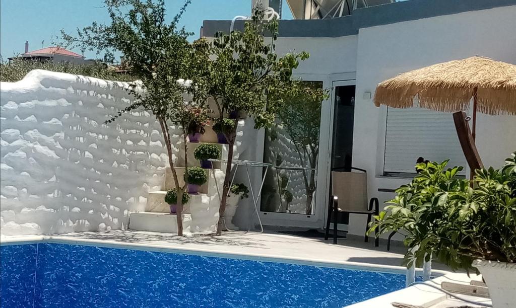 a house with a swimming pool and a white wall at Maria's little treasure in Pigianos Kampos