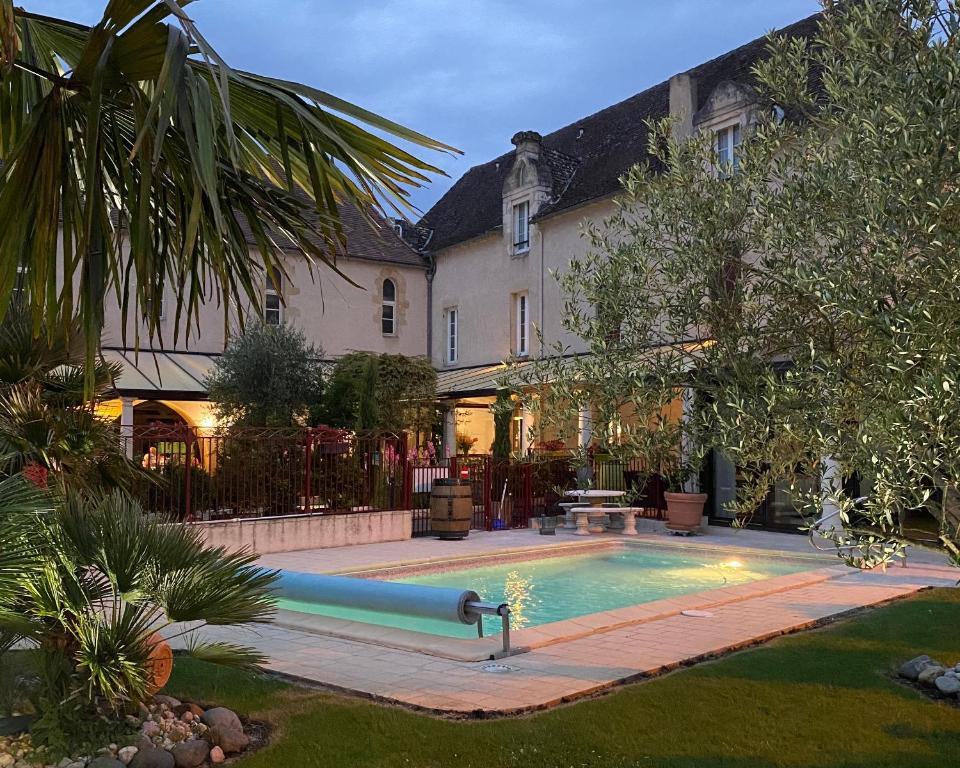 a large house with a swimming pool in the yard at Logis Hostellerie des Ducs in Duras