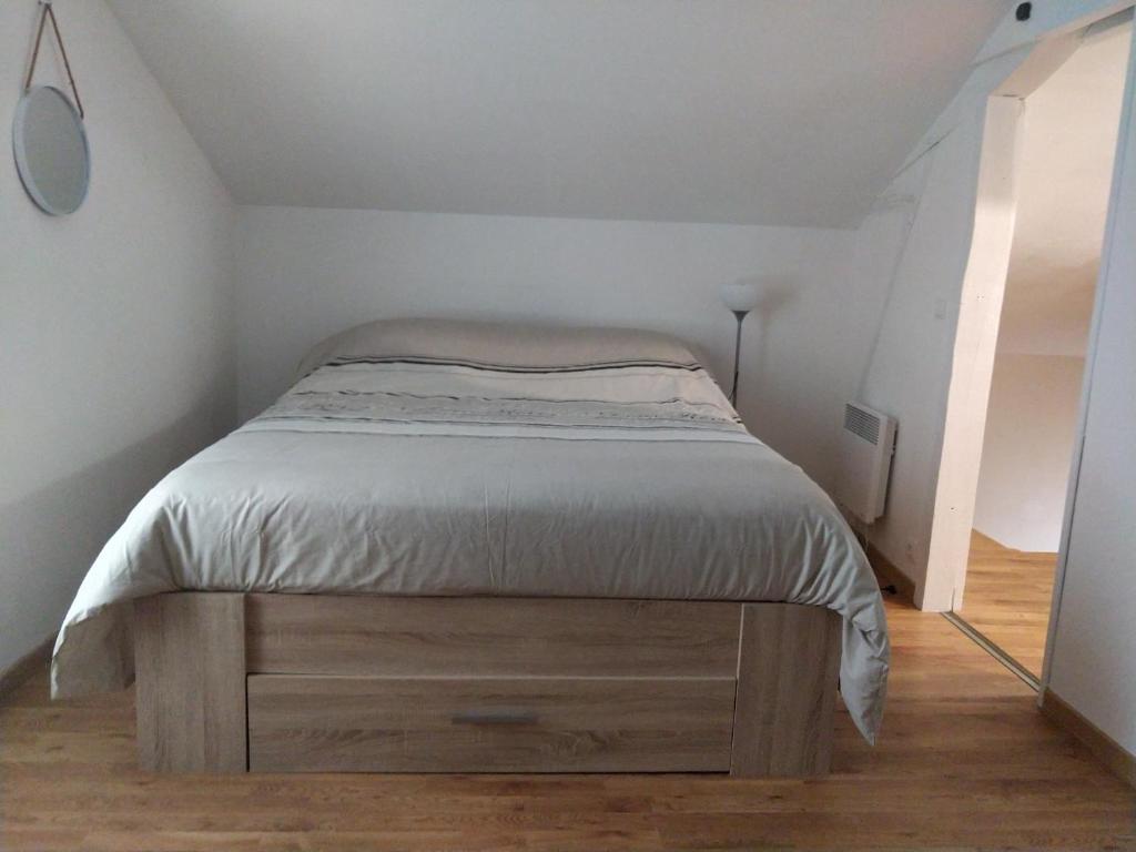 a bedroom with a bed with a dresser and a mirror at Au bon acceuil in Channay-sur-Lathan