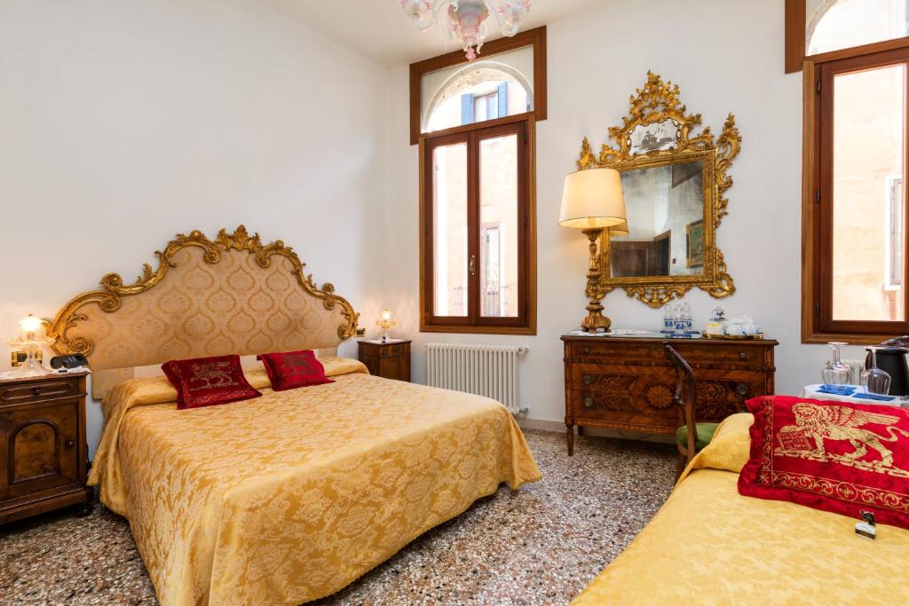 a bedroom with two beds and a mirror at Luxury Venetian Rooms in Venice