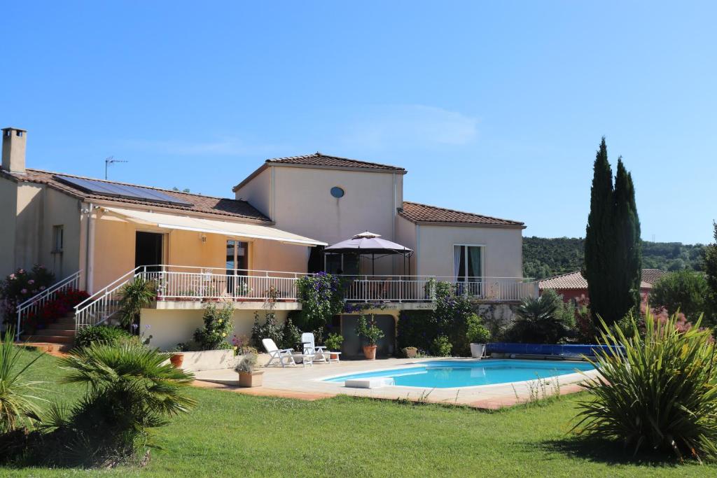 a villa with a swimming pool and a house at chambres d'hôtes du capimont in Hérépian