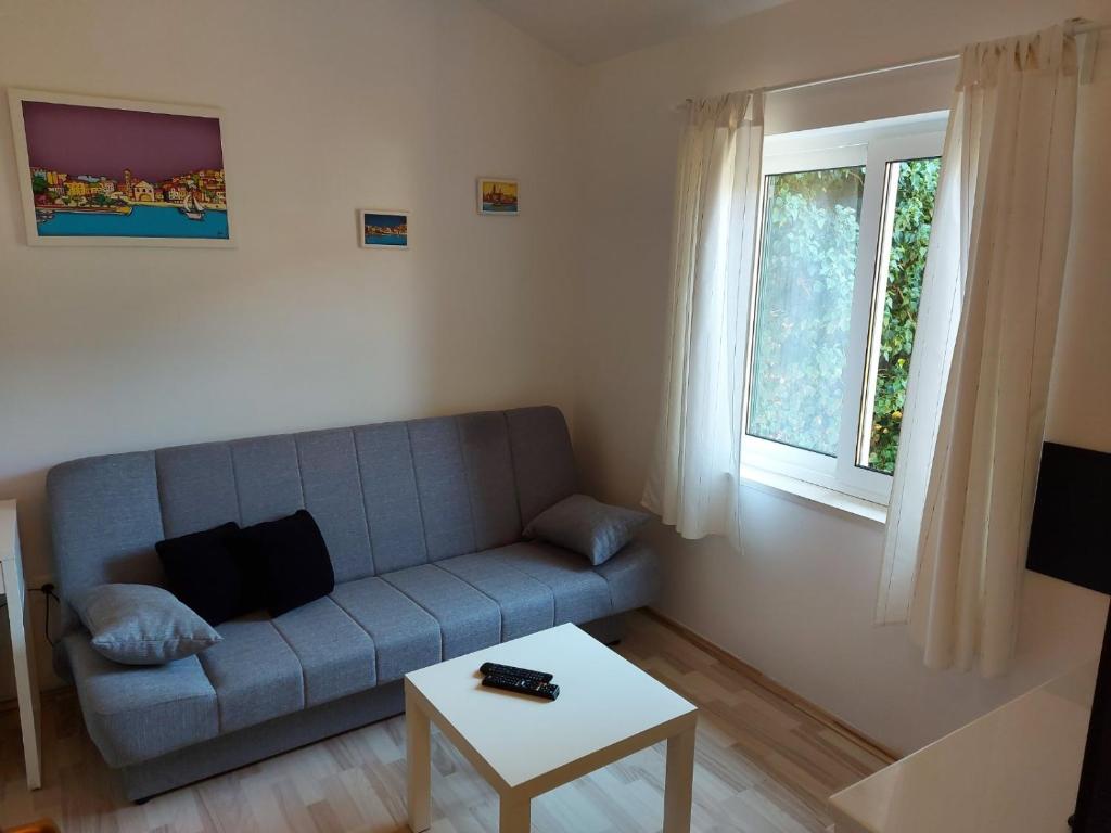 a living room with a blue couch and a table at Pension Oaza in Hvar