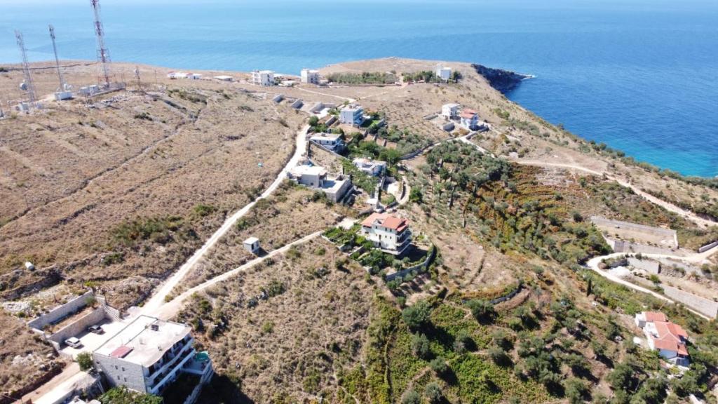 an aerial view of a house on a hill next to the ocean at Vila Llaka in Himare