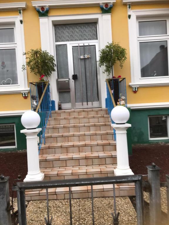 a front door of a house with a set of stairs at Ferienwohnung Ils in Wittmund in Wittmund