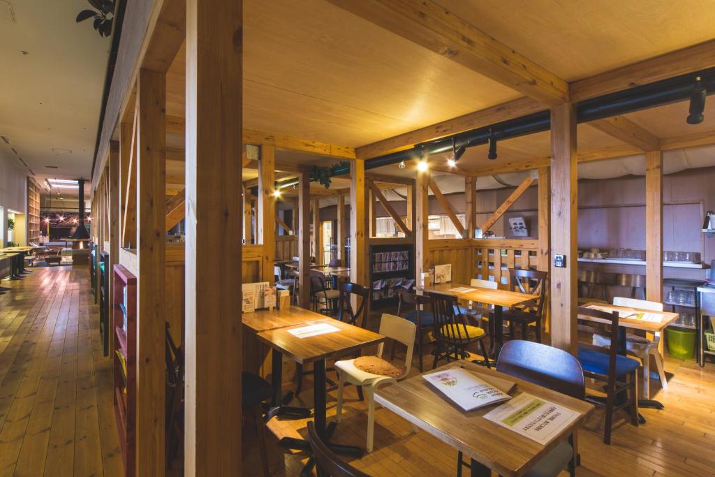 un restaurante vacío con mesas y sillas de madera en Ofuro Cafe Utatane, en Saitama
