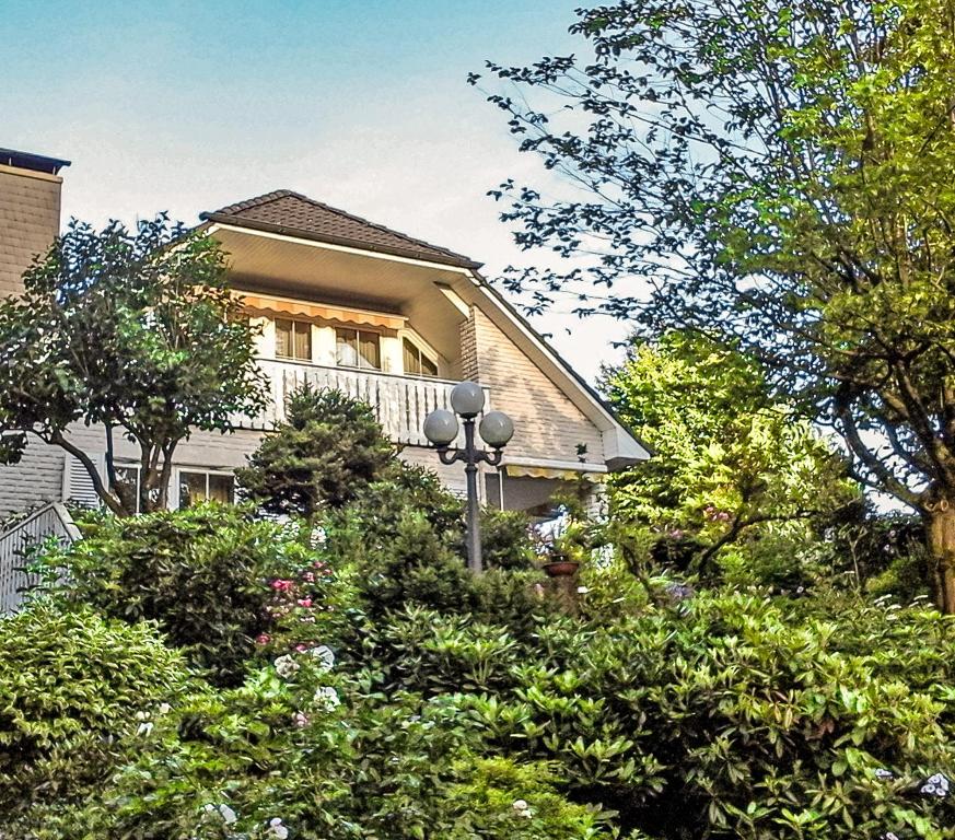 a house with a balcony and trees and bushes at Villa Stephan in Extertal