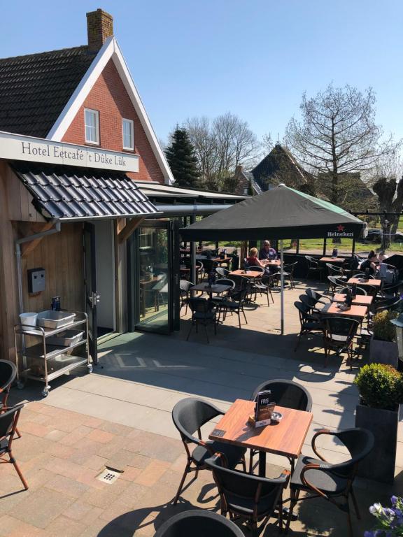 een patio van een restaurant met tafels en stoelen bij Hotel Eetcafé 't Dûke Lûk in Veenwoudsterwal