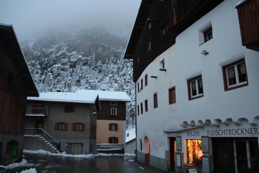 eine schneebedeckte Straße in einer Stadt mit Gebäuden in der Unterkunft Tgesa Ferrera in Schmitten