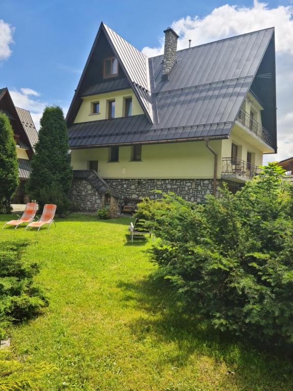 a house with a metal roof on a lawn at Durda in Poronin