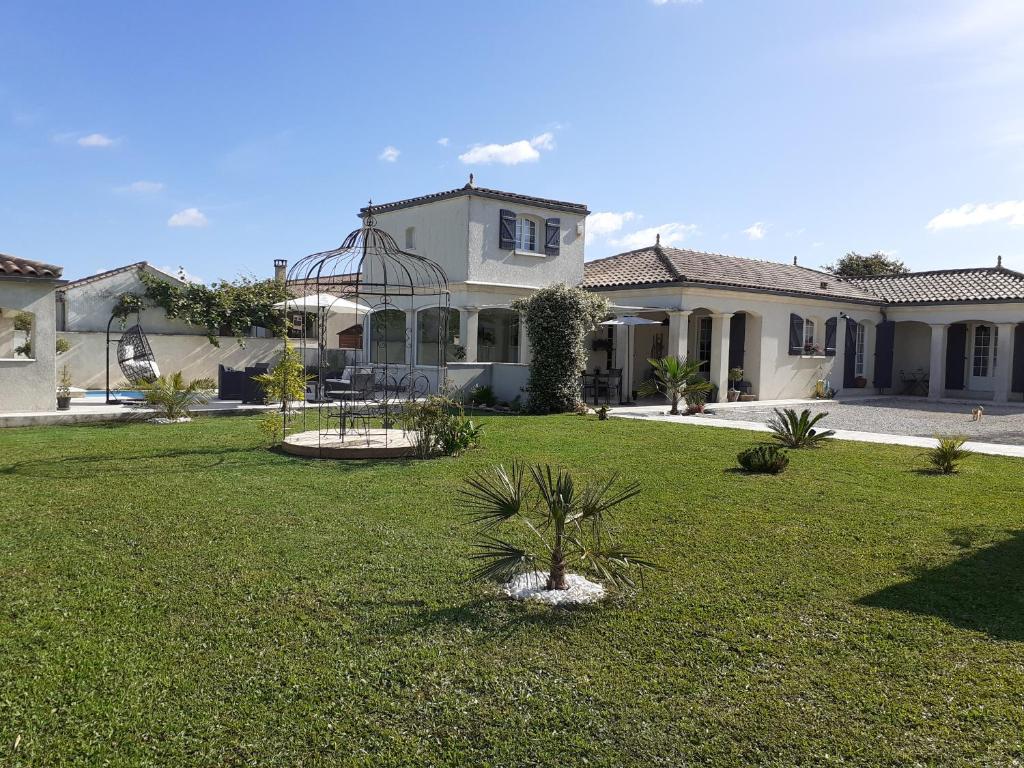 ein Haus mit einer Palme im Hof in der Unterkunft Maison d'hôtes L'air d'antan in Bias