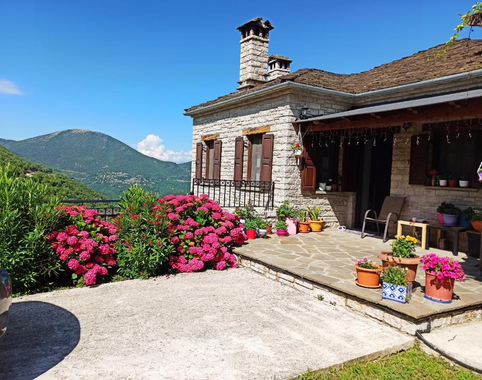 una casa con flores rosas en un patio en Foris House, en Vikos