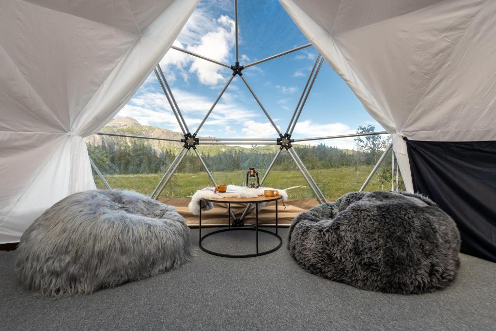 a tent with two beds and a table in it at Dyrja Domes in Hemsedal