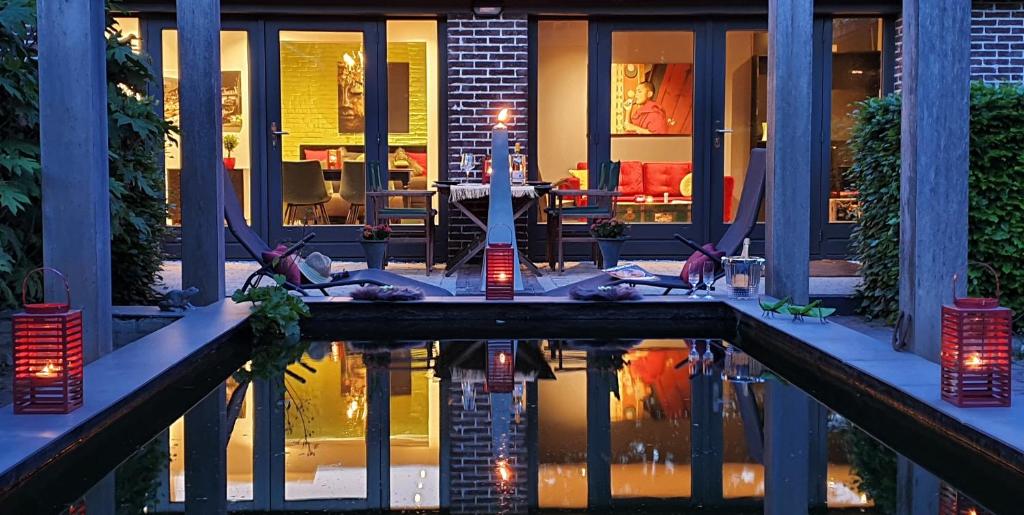 a patio with a table and a pool of water at Downtown Hideaway, B&B Grand Deluxe in Eindhoven