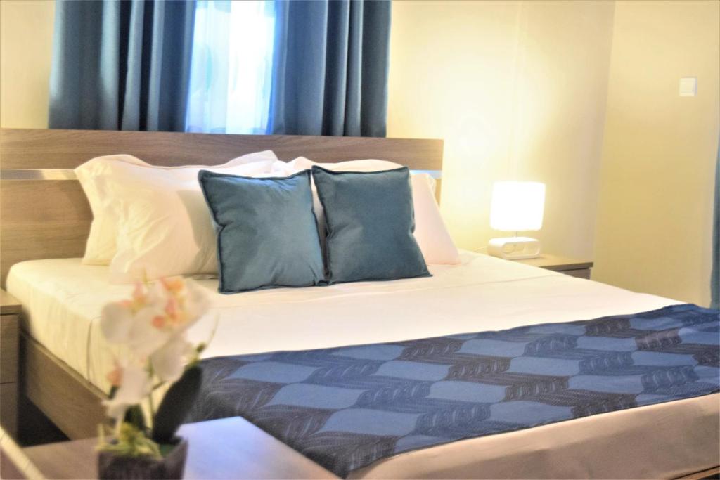 um quarto com uma cama com almofadas azuis e brancas em Montecito Apartments em Acra