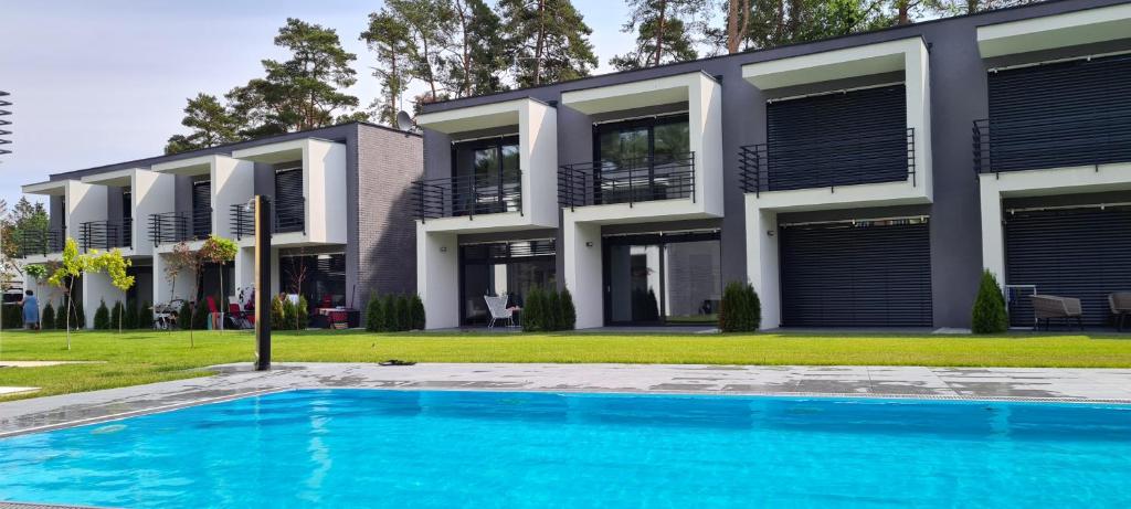 a house with a swimming pool in front of a building at BOHO MARE Apartament Pobierowo in Pobierowo